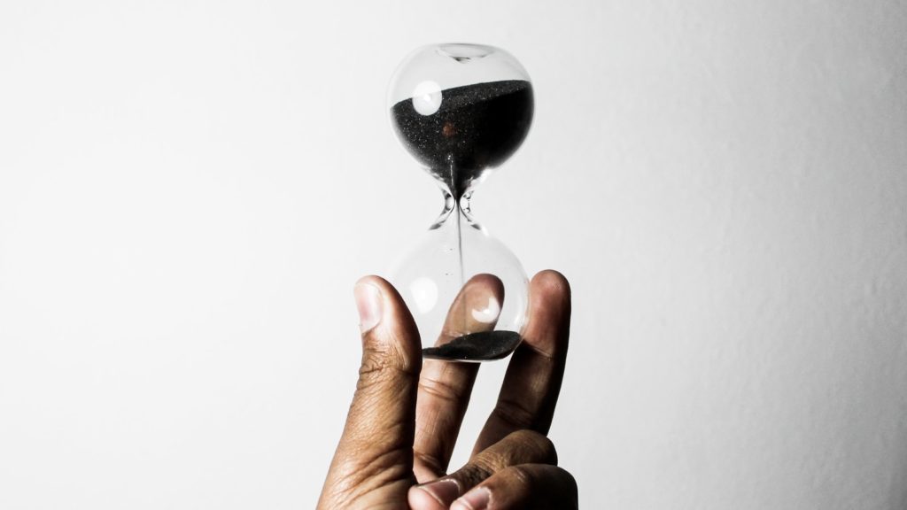 person holding hourglass as a symbol for how much time is needed for 30 day blog challenge